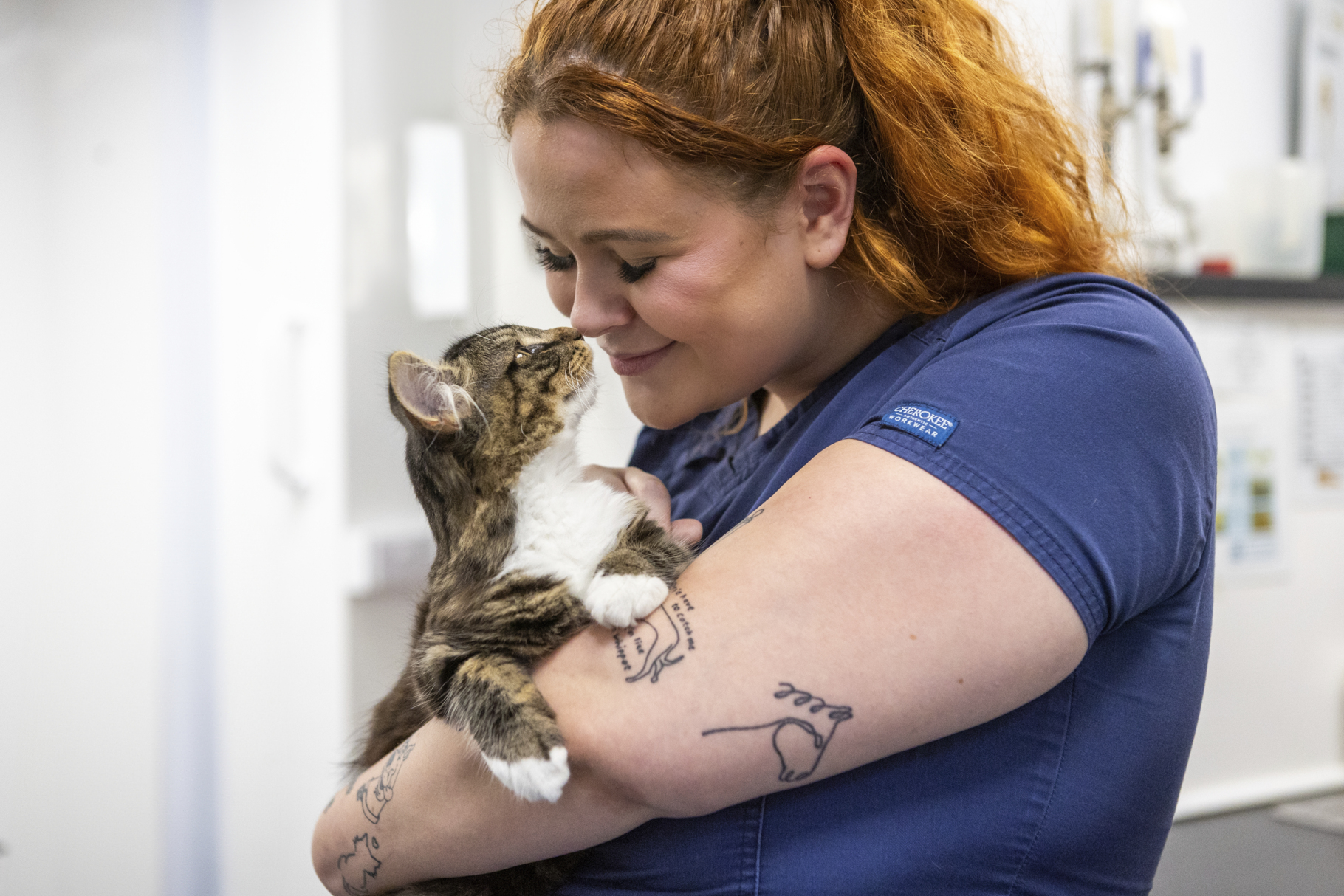 girl with ginger hair and tabby cat cuddling